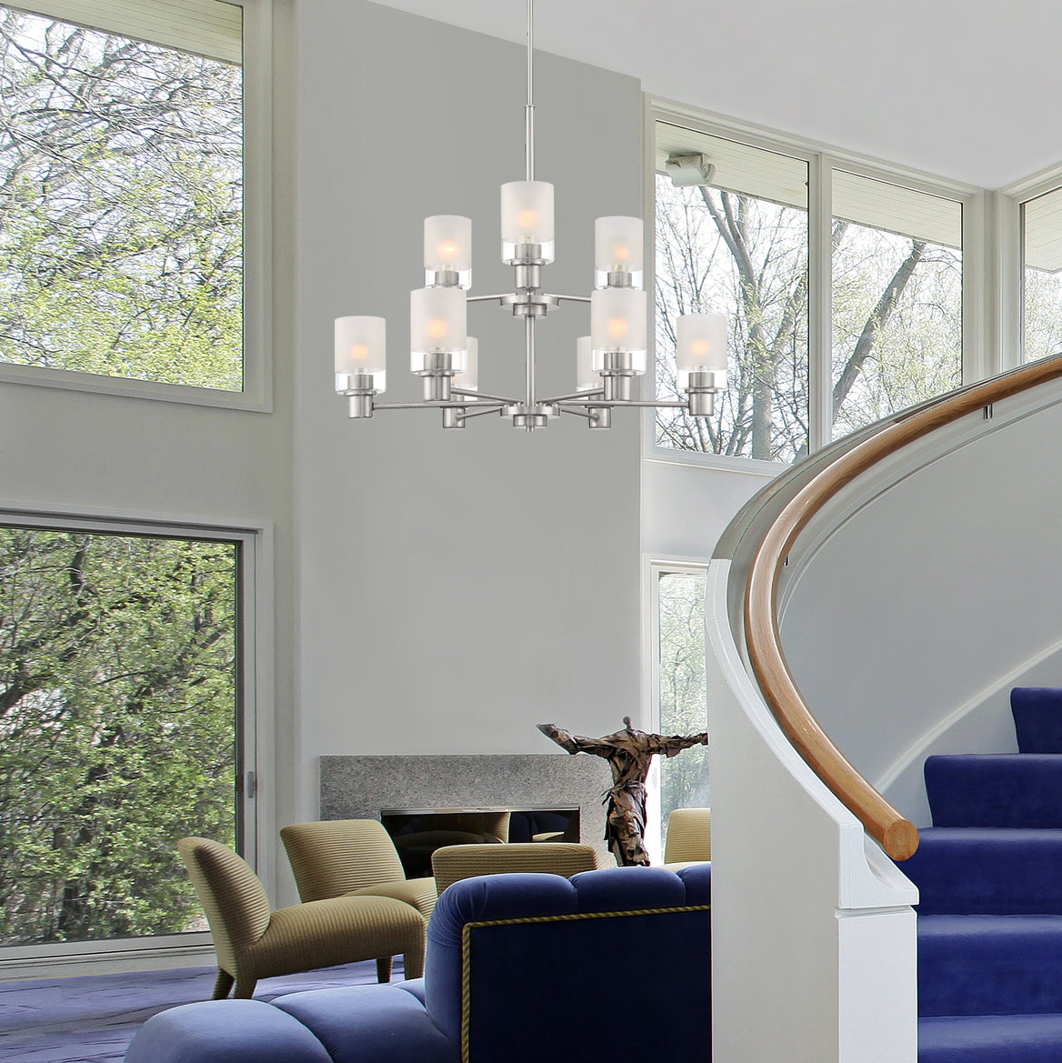 Modern living room with a chandelier, blue sofa, and large windows.